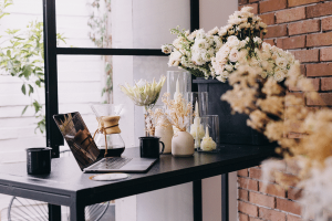 Mesa de escritório com laptop e um buquê de flores brancas
