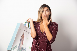 Mulher segurando sacolas de compras com ilustração do Big Ben em um fundo branco.